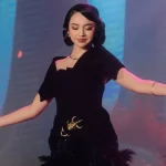 Lyodra Ginting bergaun hitam merentangkan tangan di atas panggung