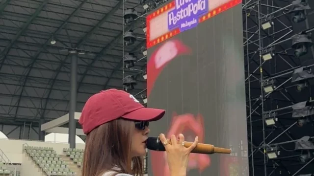 Mahalini bertopi merah memegang mikrofon di panggung berlayar Latihan Pestapora Malaysia