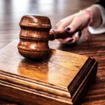 Palu sidang tergeletak di atas landasan kayu di meja pengadilan