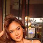 Marion Jola berpose dengan rambut tergerai di sebuah kafe