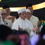 Menteri Agama dan sejumlah tokoh berpakaian putih menengadahkan tangan memanjatkan doa bersama di atas panggung