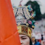 Ilustrasi pawai budaya dengan busana tradisional.