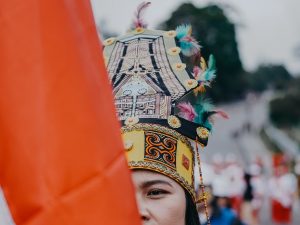 Ilustrasi pawai budaya dengan busana tradisional.