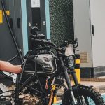 Ilustrasi sepeda motor listrik di stasiun pengisian daya.