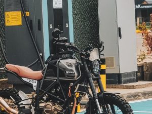 Ilustrasi sepeda motor listrik di stasiun pengisian daya.