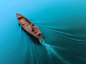 Perahu kayu melaju sendirian di perairan luas