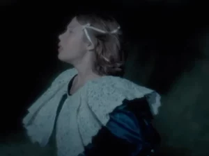 Sosok berbusana putih dalam cuplikan video musik bernuansa gelap