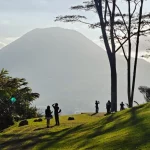 Bukit berumput dengan latar gunung di Tomohon, Sulawesi Utara