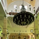 Mushaf Al-Quran terbuka di atas rehal di dalam masjid