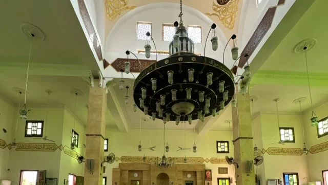Mushaf Al-Quran terbuka di atas rehal di dalam masjid