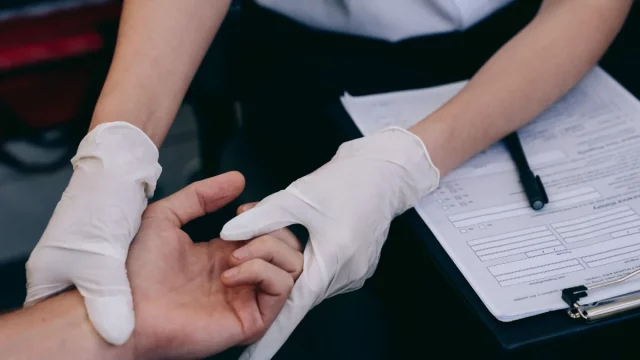 Dokter bersarung tangan memeriksa sendi tangan pasien