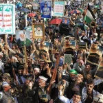 Ribuan pendukung Houthi menggelar aksi massa sambil membawa senjata dan poster di Yaman.