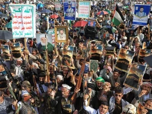 Ribuan pendukung Houthi menggelar aksi massa sambil membawa senjata dan poster di Yaman.