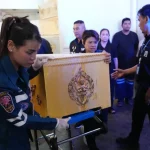 Petugas penyelamat mengangkat peti jenazah berhias emas dari brankar di sebuah rumah sakit