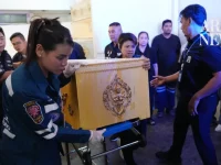 Petugas penyelamat mengangkat peti jenazah berhias emas dari brankar di sebuah rumah sakit