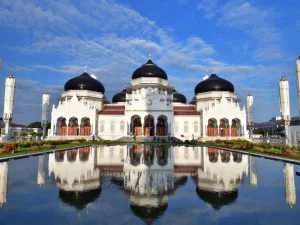 Masjid Raya Baiturrahman di Banda Aceh dengan kubah hitam dan bayangannya di kolam pantul