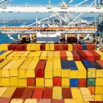 Peti kemas menumpuk di dermaga sebuah pelabuhan