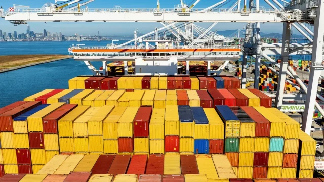 Peti kemas menumpuk di dermaga sebuah pelabuhan