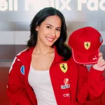 Pevita Pearce mengenakan jaket merah Scuderia Ferrari sambil memegang topi bertanda tangan di fasilitas Shell Helix, Italia
