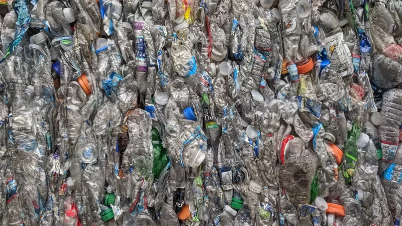 Tumpukan botol plastik PET bekas yang sudah dipadatkan menjadi bal.