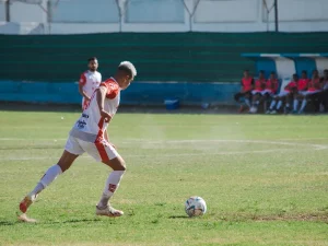 Pesepak bola menggiring bola di lapangan