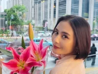 Prilly Latuconsina menoleh ke kamera sambil membawa bunga lili