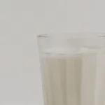 Segelas susu sapi segar di atas kain putih