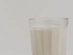 Segelas susu sapi segar di atas kain putih