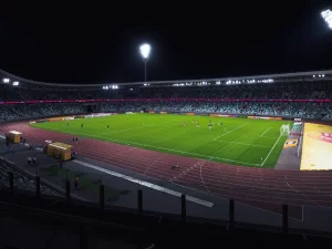 Ilustrasi stadion sepak bola dengan lampu menyala pada malam hari.
