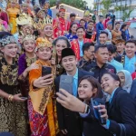 Raffi Ahmad mengenakan peci berswafoto bersama sejumlah anak muda berbusana adat Nusantara