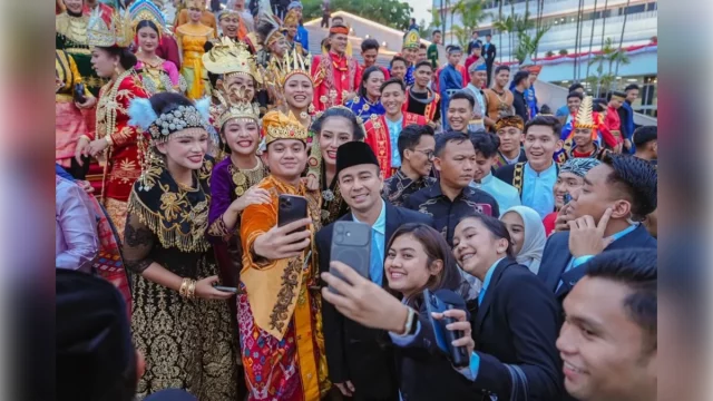 Raffi Ahmad mengenakan peci berswafoto bersama sejumlah anak muda berbusana adat Nusantara