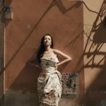 Raline Shah mengenakan gaun putih bercorak berpose di jalanan kota Italia