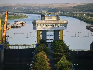 Bangunan pengendali pintu air di Sungai Danube dengan menara kuning dan aliran sungai yang tenang