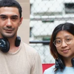 Reza Rahadian dan Sam Manacsa berpose bersama mengenakan headphone produksi di lokasi syuting
