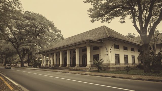Ilustrasi bangunan rumah sakit bergaya Indis di tepi jalan lengang