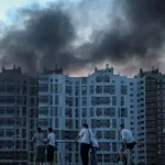 Asap hitam membumbung dari blok apartemen yang terkena serangan udara di Ukraina.