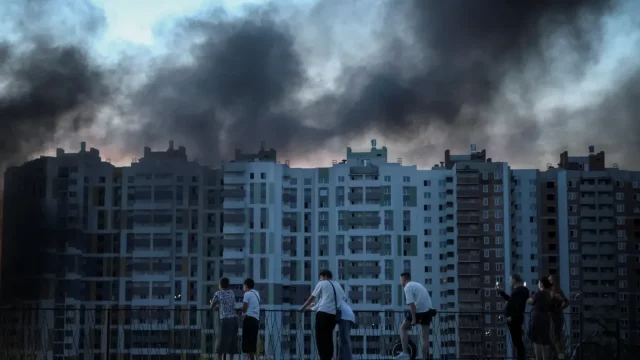 Asap hitam membumbung dari blok apartemen yang terkena serangan udara di Ukraina.
