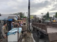 Petugas Satpol PP Kota Padang mengangkut lapak pedagang dari trotoar kawasan Pasar Alai