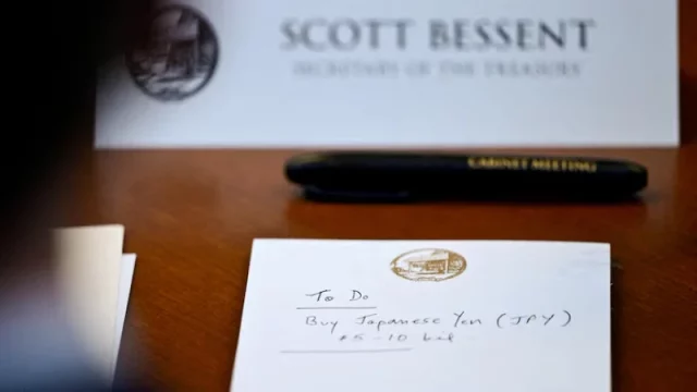 Catatan bertuliskan To Do Buy Japanese Yen di depan papan nama Scott Bessent