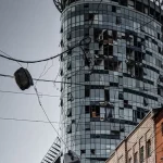 Gedung bertingkat dengan jendela hancur dan dinding menghitam di sebuah kota di Ukraina