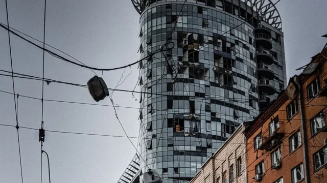 Gedung bertingkat dengan jendela hancur dan dinding menghitam di sebuah kota di Ukraina