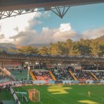 Ilustrasi tribune stadion menjelang senja.