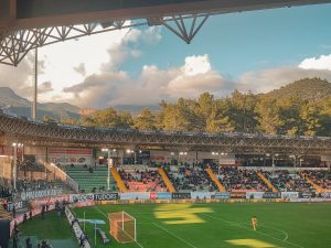 Ilustrasi tribune stadion menjelang senja.