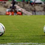 Ilustrasi bola-bola latihan di lapangan rumput.