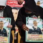 Warga memegang poster bergambar dokter Hussam Abu Safia dalam aksi solidaritas di Ramallah