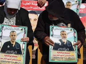 Warga memegang poster bergambar dokter Hussam Abu Safia dalam aksi solidaritas di Ramallah