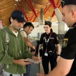 Petugas Policia Nacional Spanyol memeriksa dokumen seorang penumpang di terminal bandara