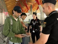 Petugas Policia Nacional Spanyol memeriksa dokumen seorang penumpang di terminal bandara