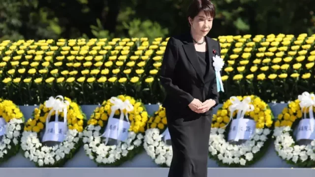 Perdana Menteri Jepang Sanae Takaichi berdiri di depan karangan bunga pada upacara peringatan di Taman Peringatan Perdamaian Hiroshima
