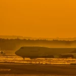 Pesawat Boeing 747 di landasan bandara saat matahari terbenam